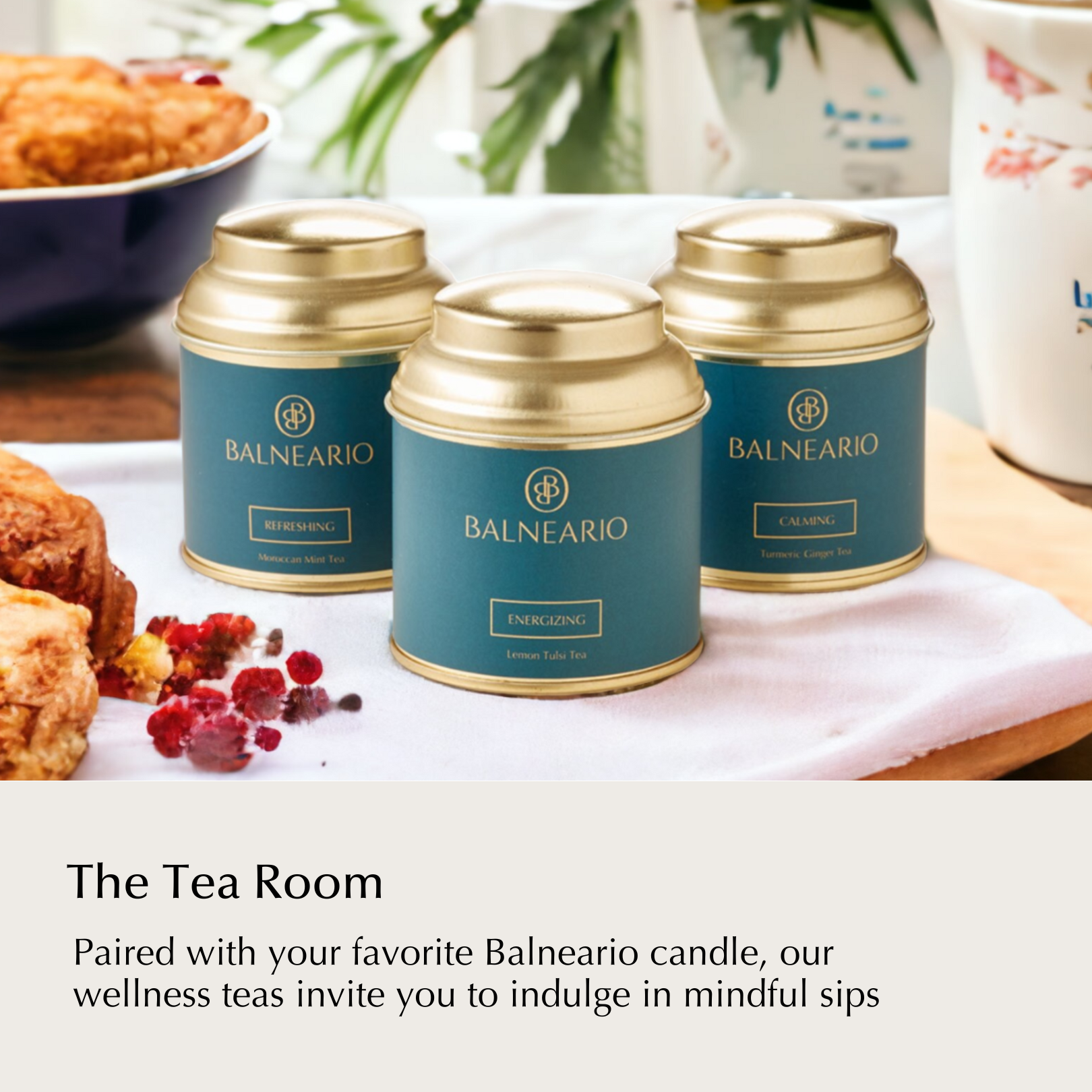 Balneario Wellness Tea Trio in teal tins with gold lids on a kitchen table surrounded by baked goods.