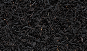 Close up of black tea leaves, evoking the woody & amber fragrance notes prominent in the Balneario Laconia candle